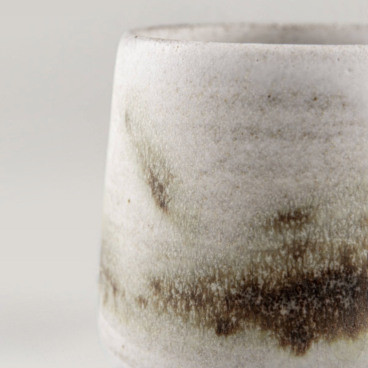 Side view of espresso cup with subtle green and brown glaze accents, handmade kitchenware for gifting.