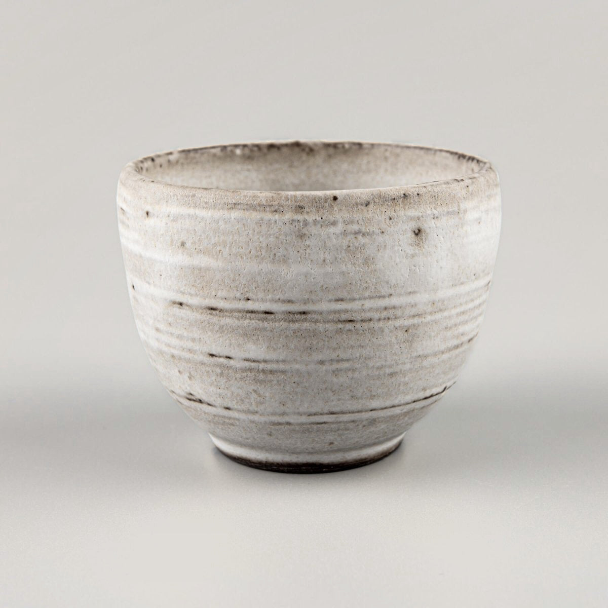 Minimalist ceramic coffee mugs with curved edges and a flat base, ideal for boutique hotels and fine dining restaurants.