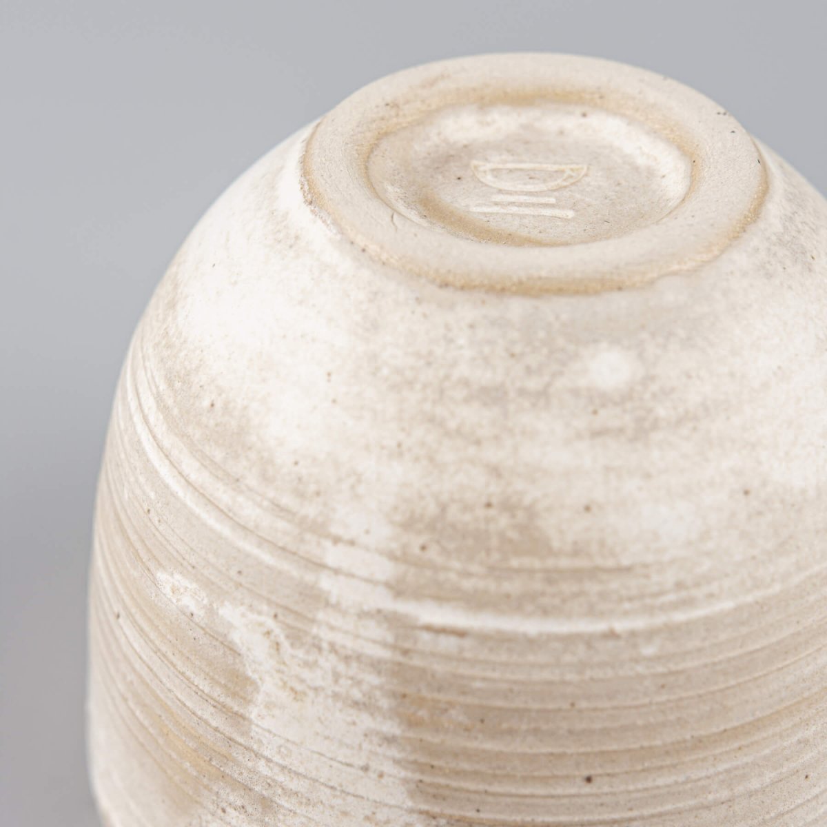 Handmade ceramic coffee cup side view with engraved lines, perfect for boutique hotel kitchens.