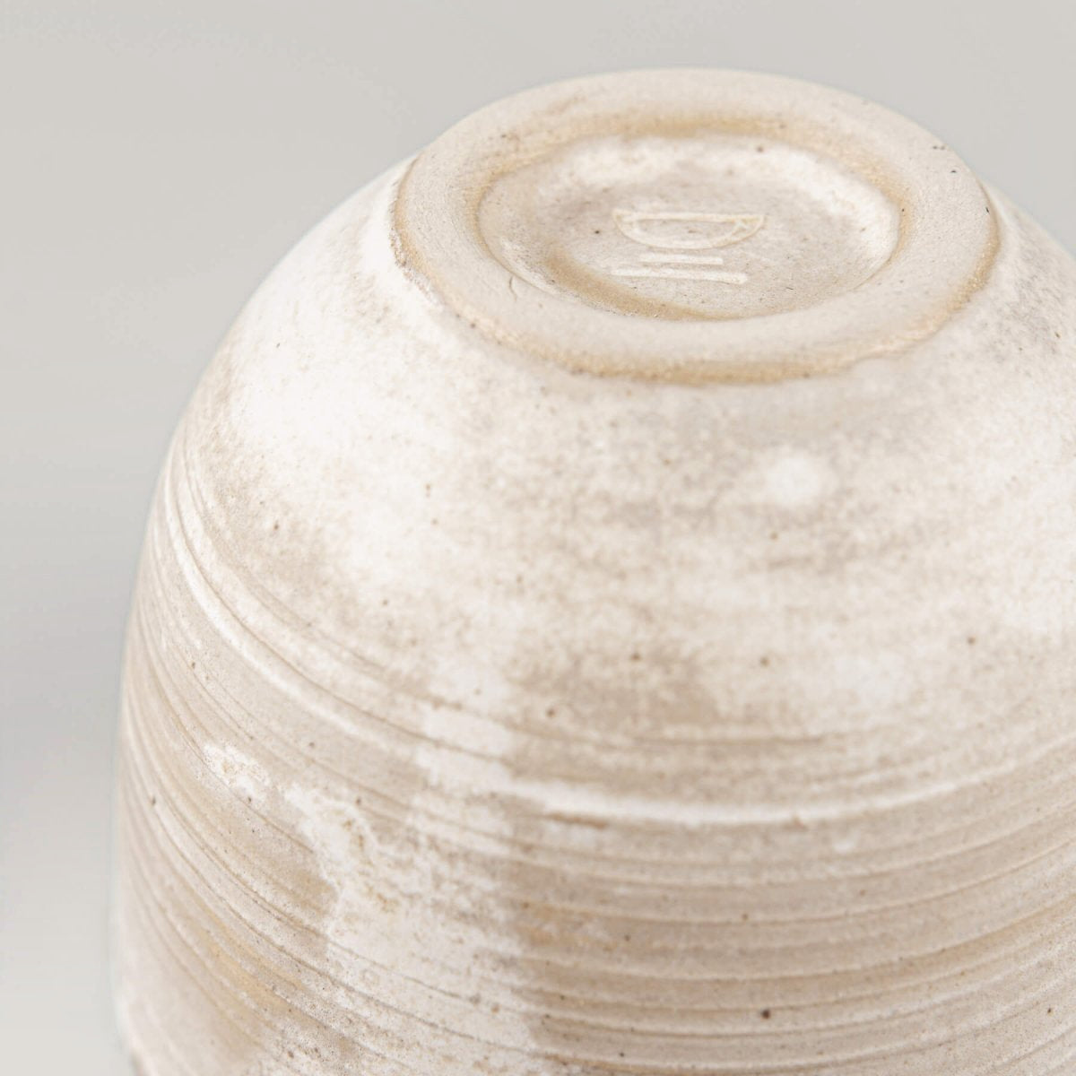 Handmade ceramic coffee cup side view with engraved lines, perfect for boutique hotel kitchens.