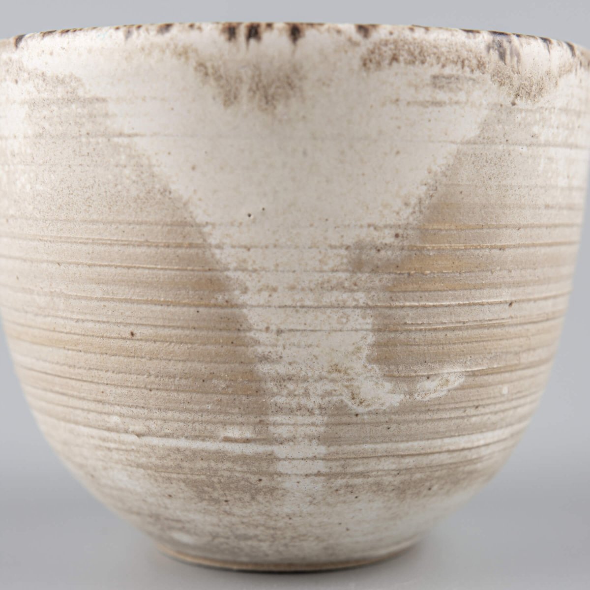 Detailed texture of rustic stoneware coffee cup with artisan glaze, ideal for interior design settings.