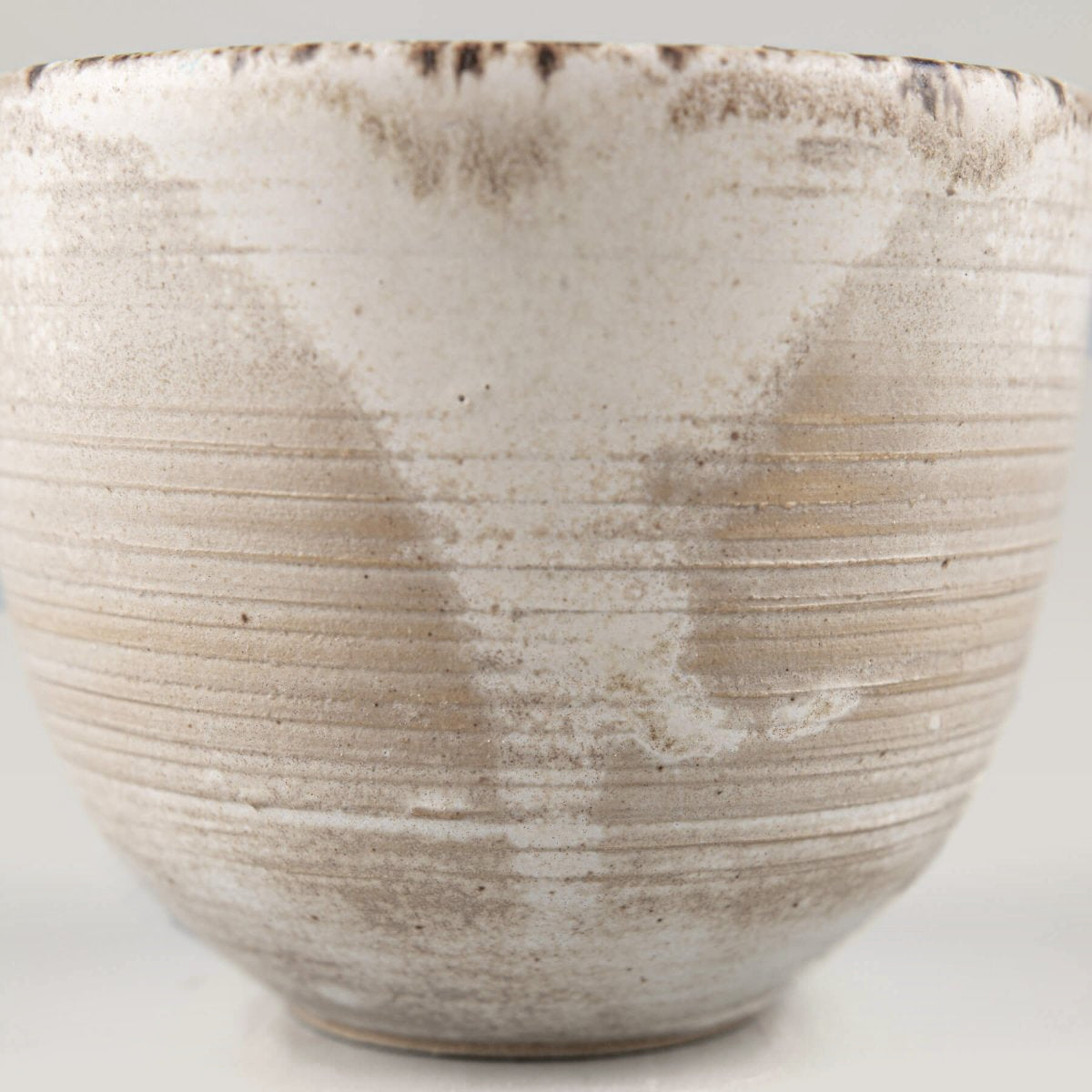 Detailed texture of rustic stoneware coffee cup with artisan glaze, ideal for interior design settings.