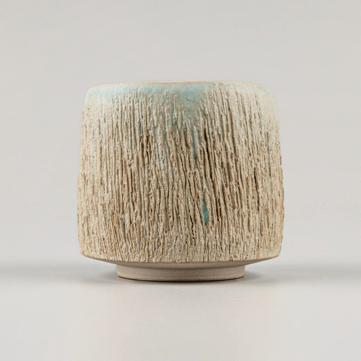 Pottery mugs with textured exterior and aqua-glazed interior for fine dining and home decor.