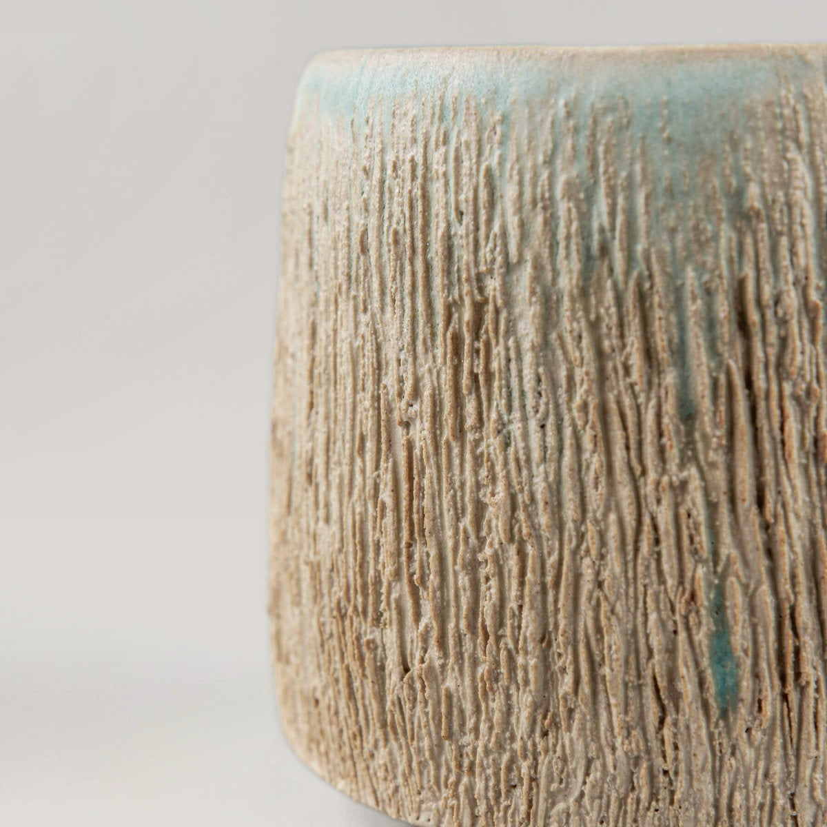 Side view of aqua glazed pottery mug, handmade design for boutique hotels and interior design.