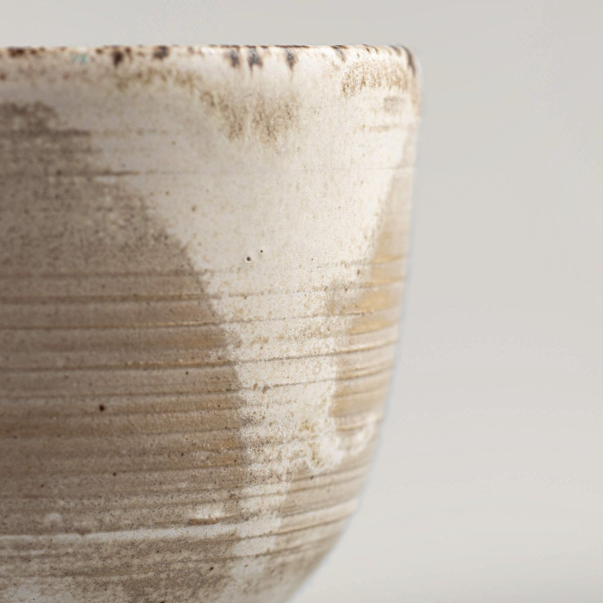 Side profile of artisan stoneware coffee cup with engraved lines and matte glaze, perfect for collectible pottery.