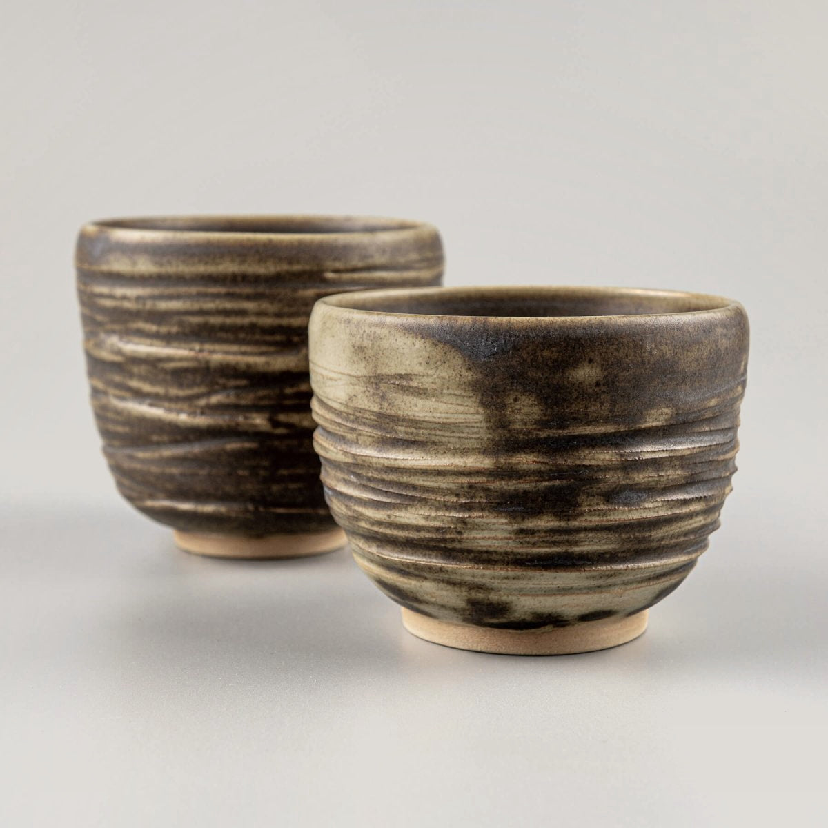 Handmade ceramic mugs with textured carving and olive-green glaze, ideal for home, boutique hotel, and fine dining tableware.