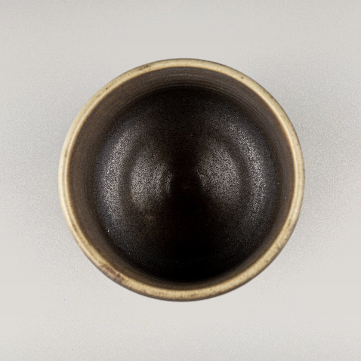 Top view of handmade ceramic mug with dark interior glaze, designed for fine dining restaurants and private collectors.