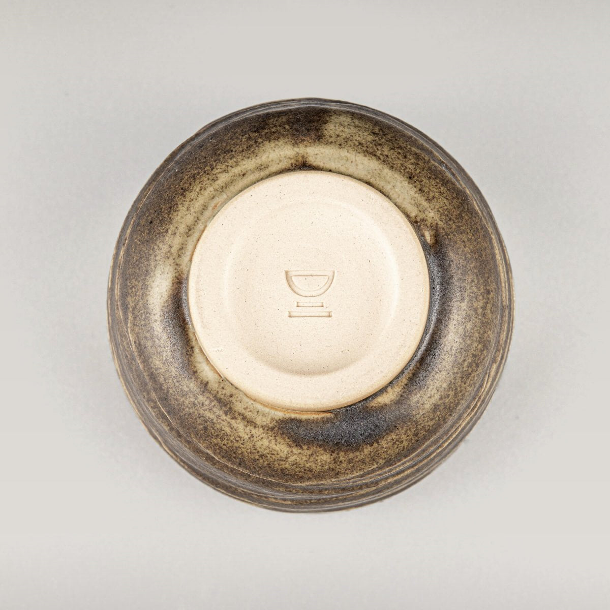 Base of ceramic mug with smooth finish, highlighting handmade craftsmanship and collectible pottery design.