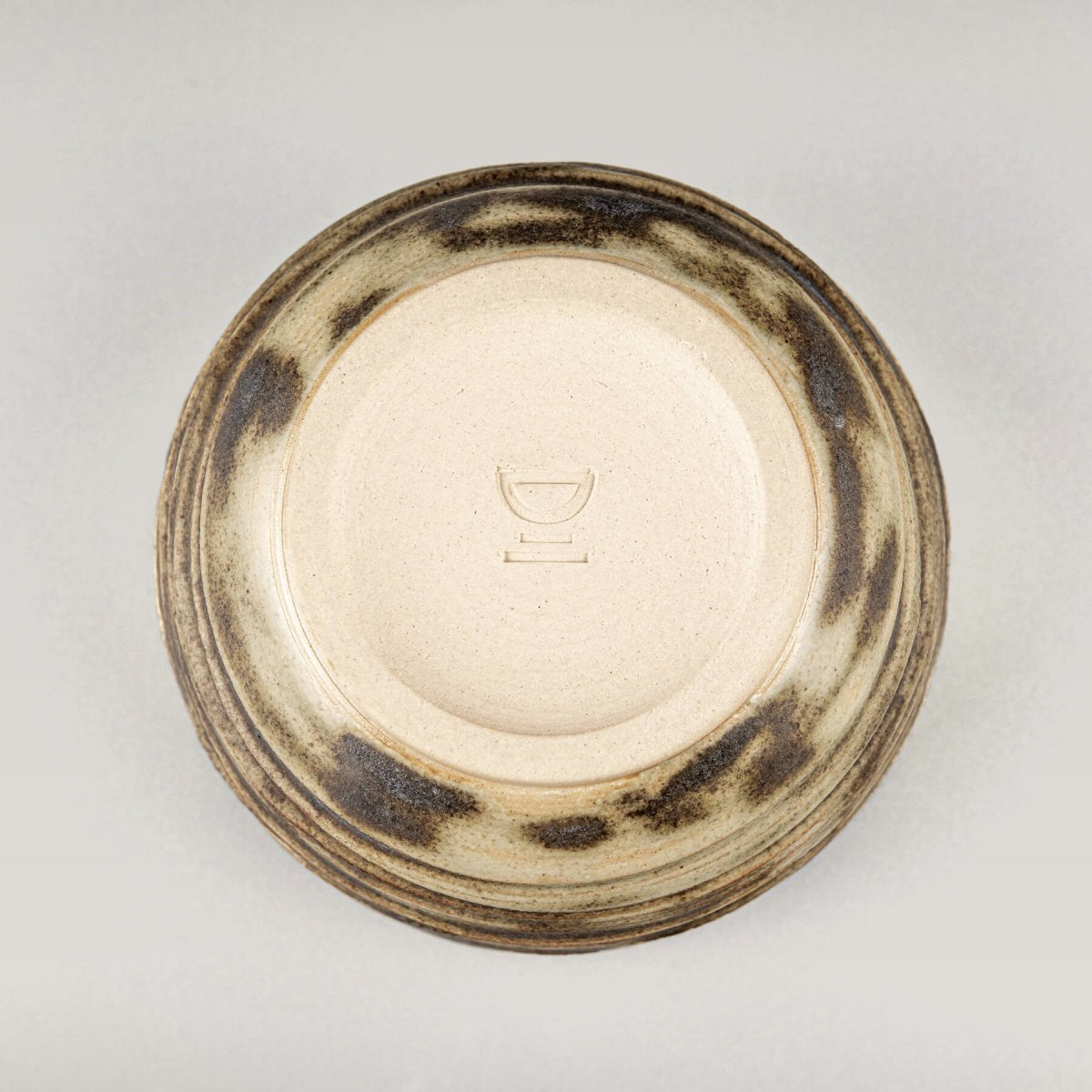 Underside of handmade ceramic mug with olive glaze details, perfect for kitchenware and interior styling.