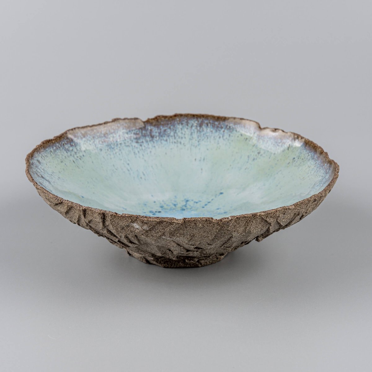Diagonal angle of ceramic bowl showcasing smooth inner surface and textured clay.