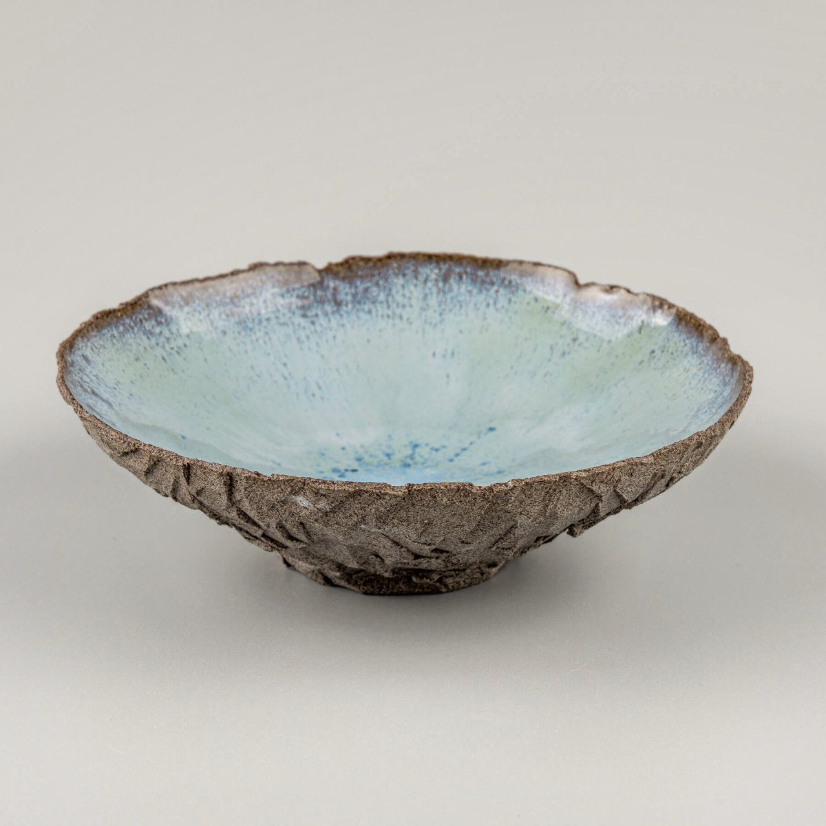 Diagonal angle of ceramic bowl showcasing smooth inner surface and textured clay.