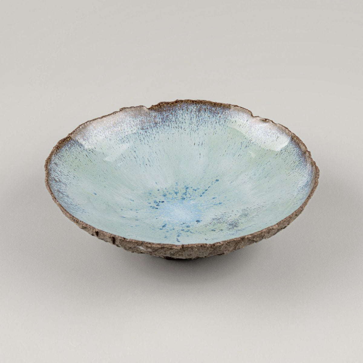 Detail of glossy blue glaze blending in ceramic bowl interior.