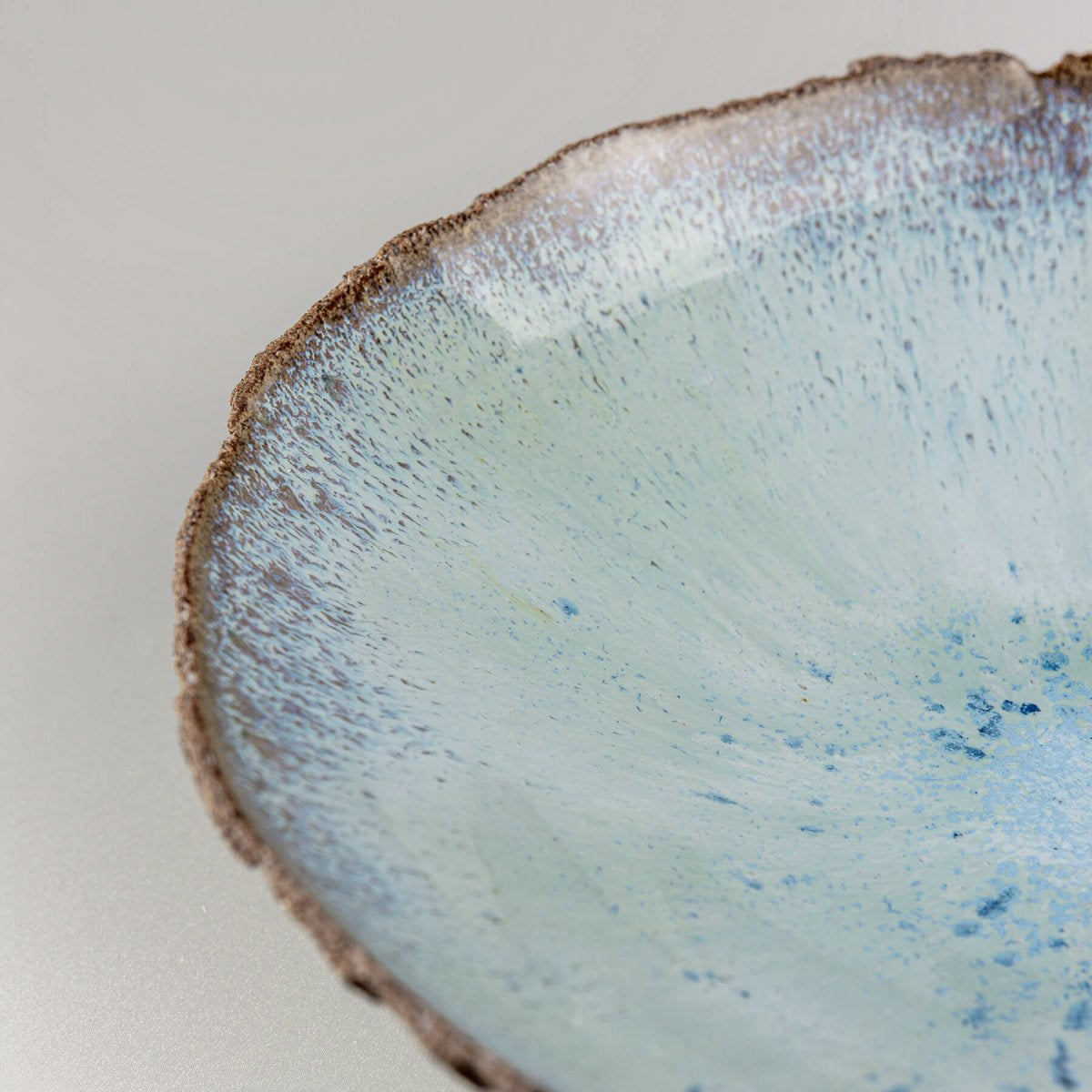 Close-up of handcrafted blue glazed surface with artistic texture.