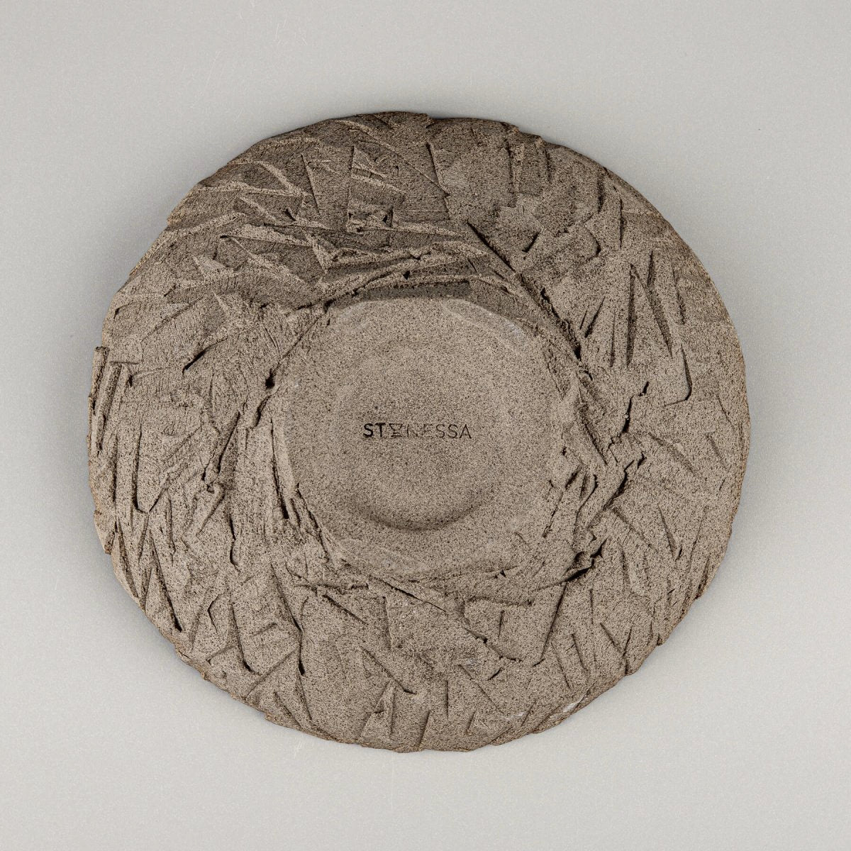 Underside of artisan bowl revealing carved base and natural clay.