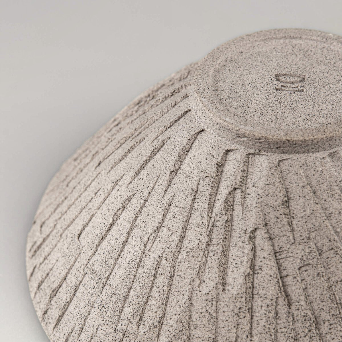 Detail of carved lines on stoneware bowl emphasizing handmade craftsmanship and decor purpose.