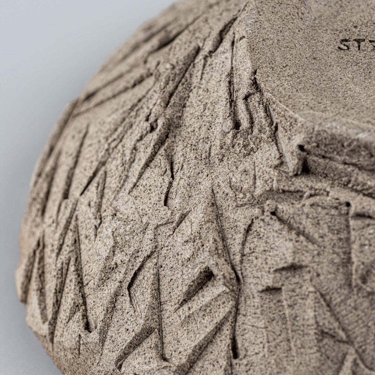 Macro view of textured stoneware surface with unique carved pattern.