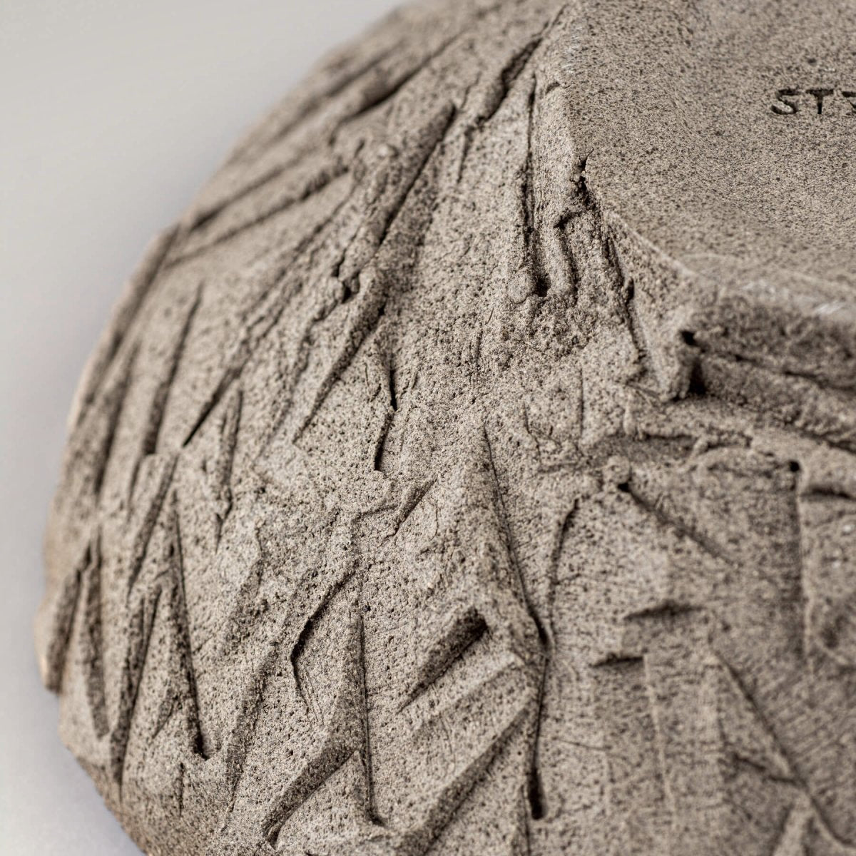 Macro view of textured stoneware surface with unique carved pattern.