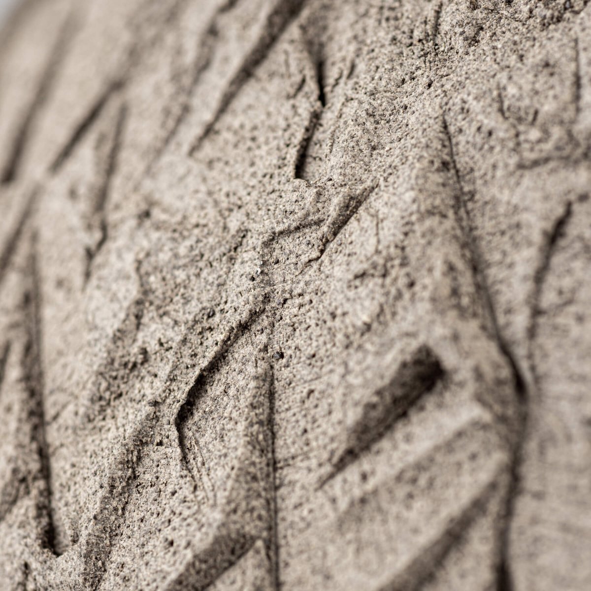 Hand-carved dark clay close-up showing raw artisan craftsmanship.