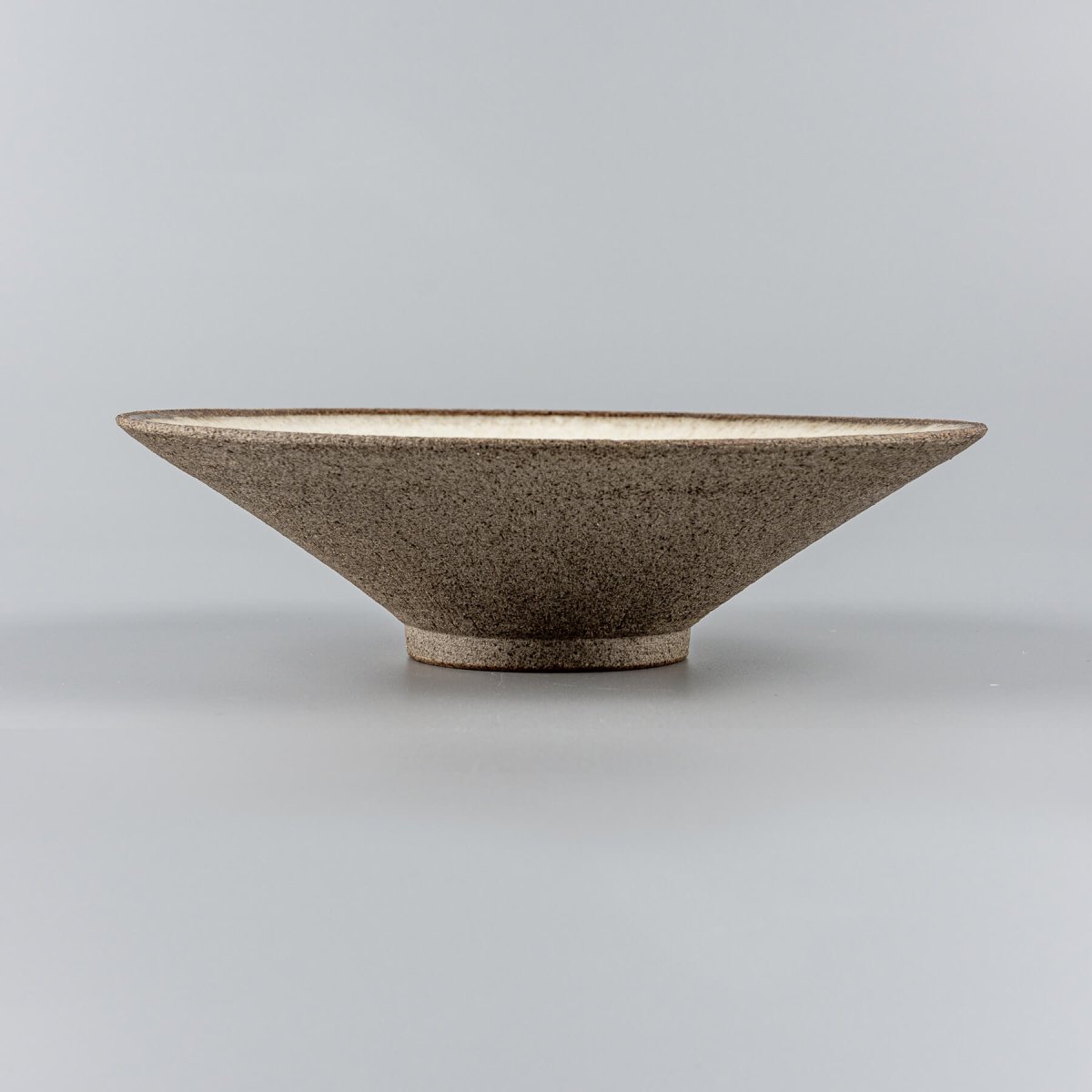 Side view of artisanal ceramic plate showcasing minimalist profile and refined craftsmanship.