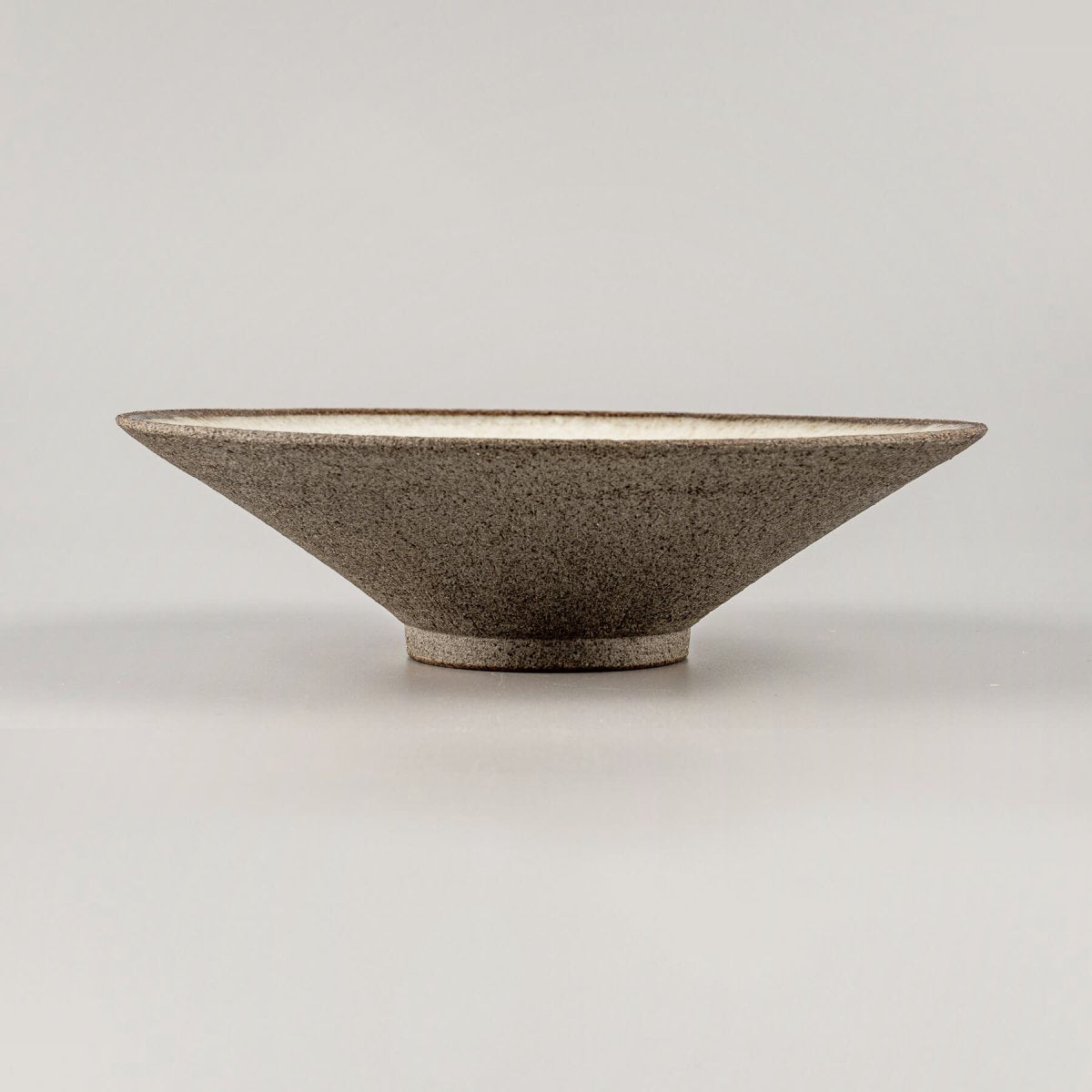 Side view of artisanal ceramic plate showcasing minimalist profile and refined craftsmanship.