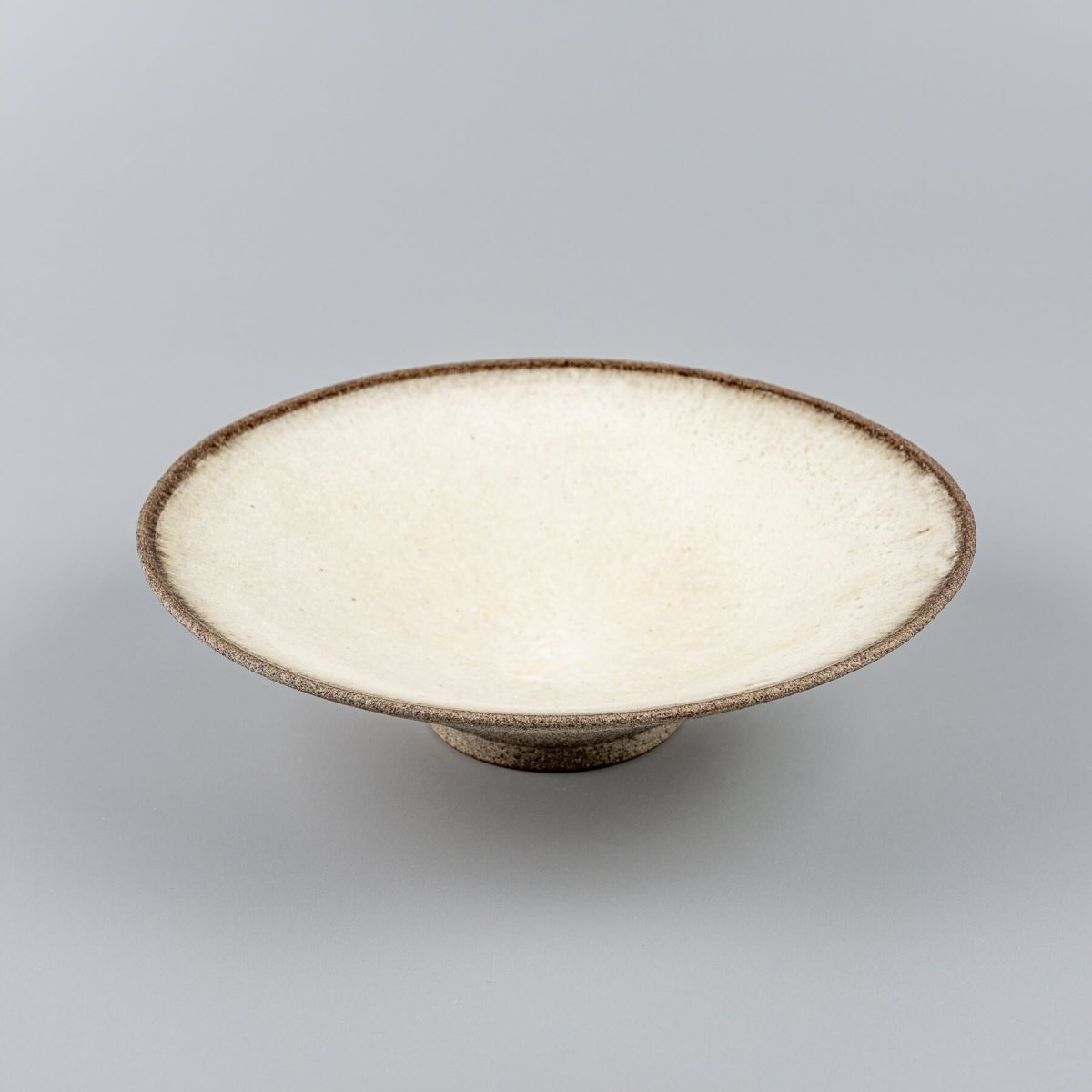 Top view of a ceramic plate with a smooth, white glazed surface for elegant plating.