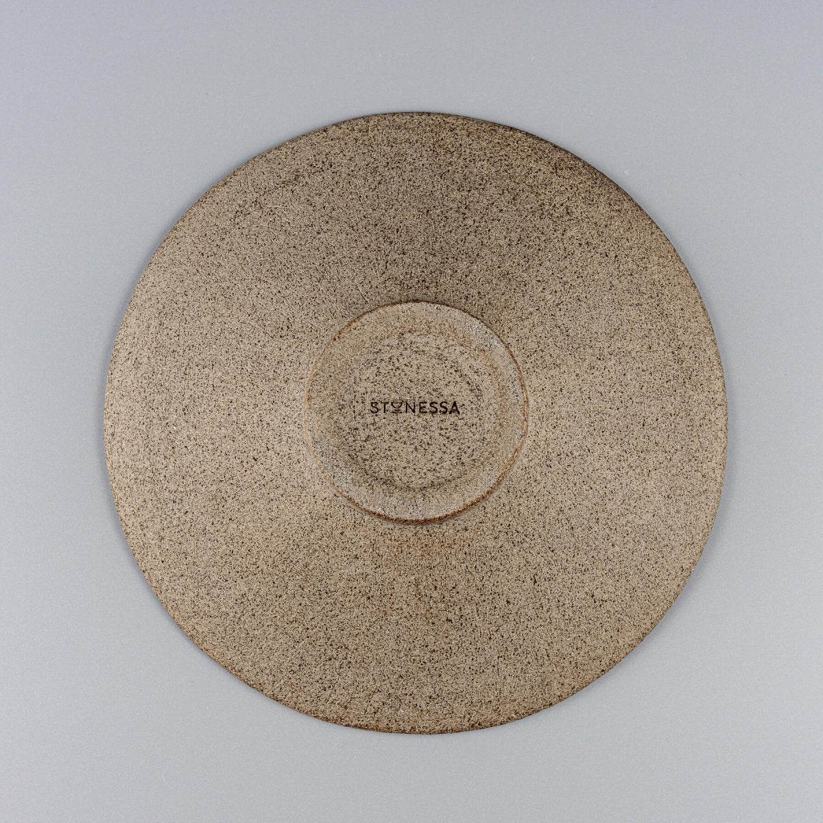 Base of artisanal ceramic plate with natural textured finish for fine dining restaurants.