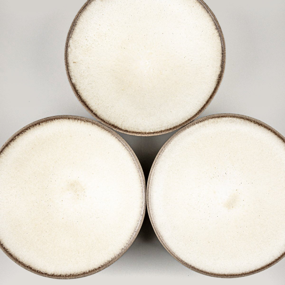 Arrangement of handmade ceramic plates for fine dining and artistic food presentation.