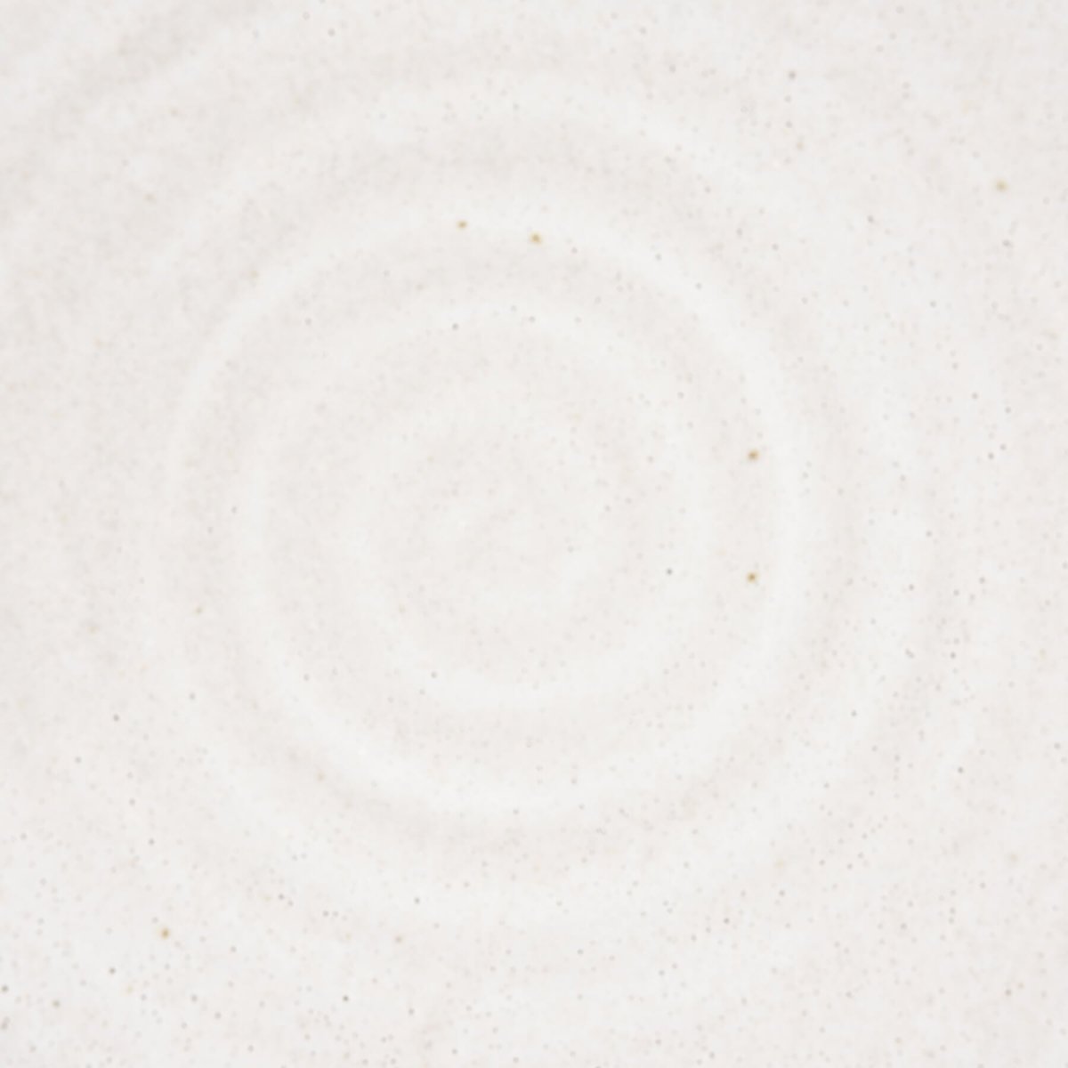 Detailed view of spiral pattern in white matte glaze on the interior of a handmade stoneware plate.