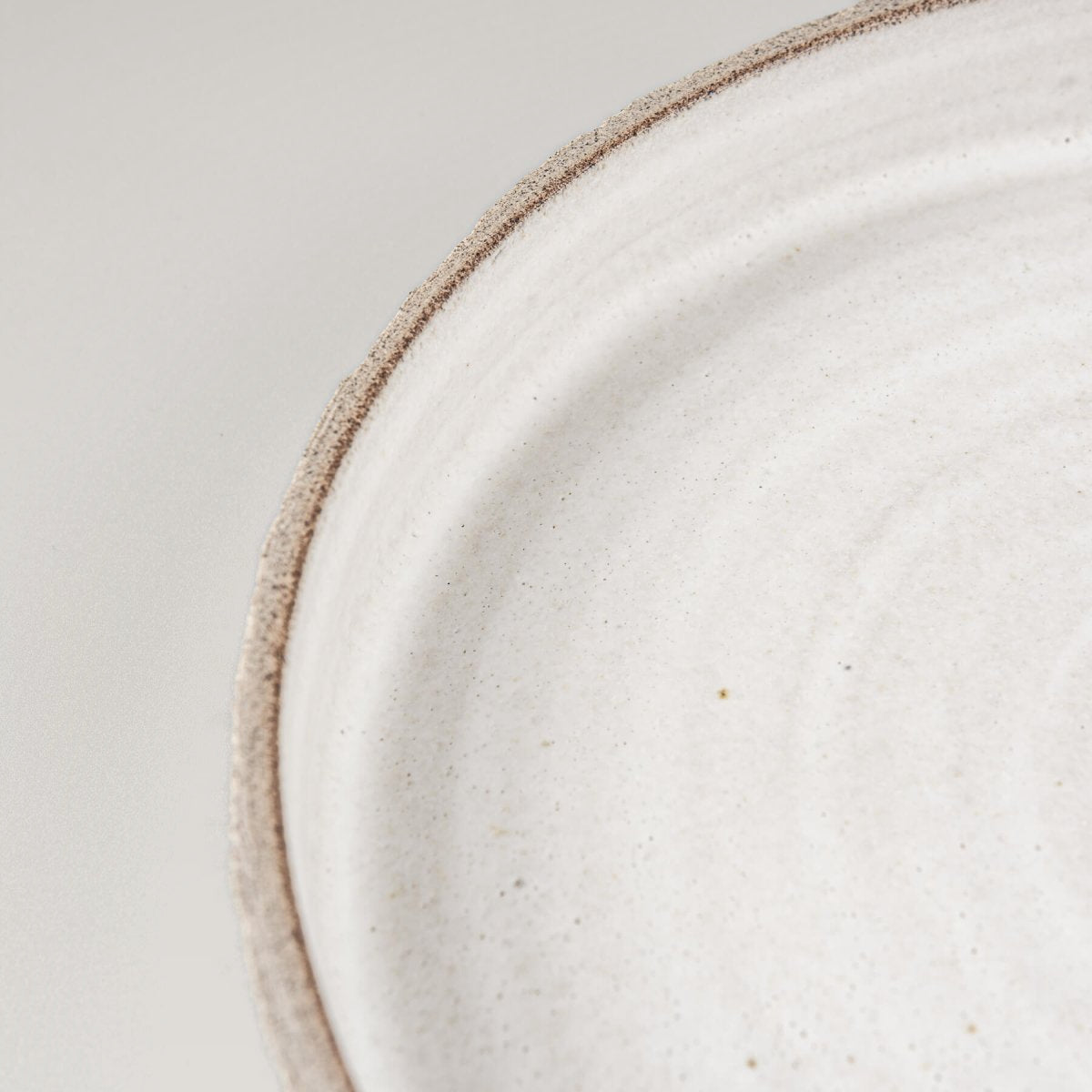 Close-up of stoneware texture and white glaze, ideal for culinary presentation.