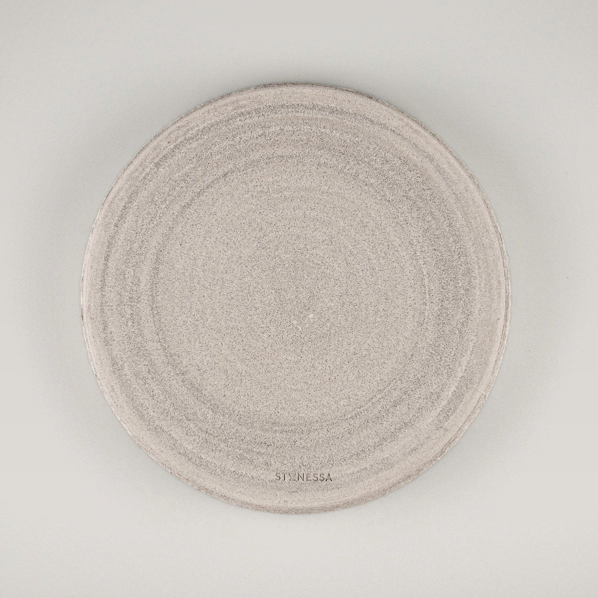 Elegant handmade ceramic plate with textured unglazed exterior and smooth white matte glazed interior for fine dining.