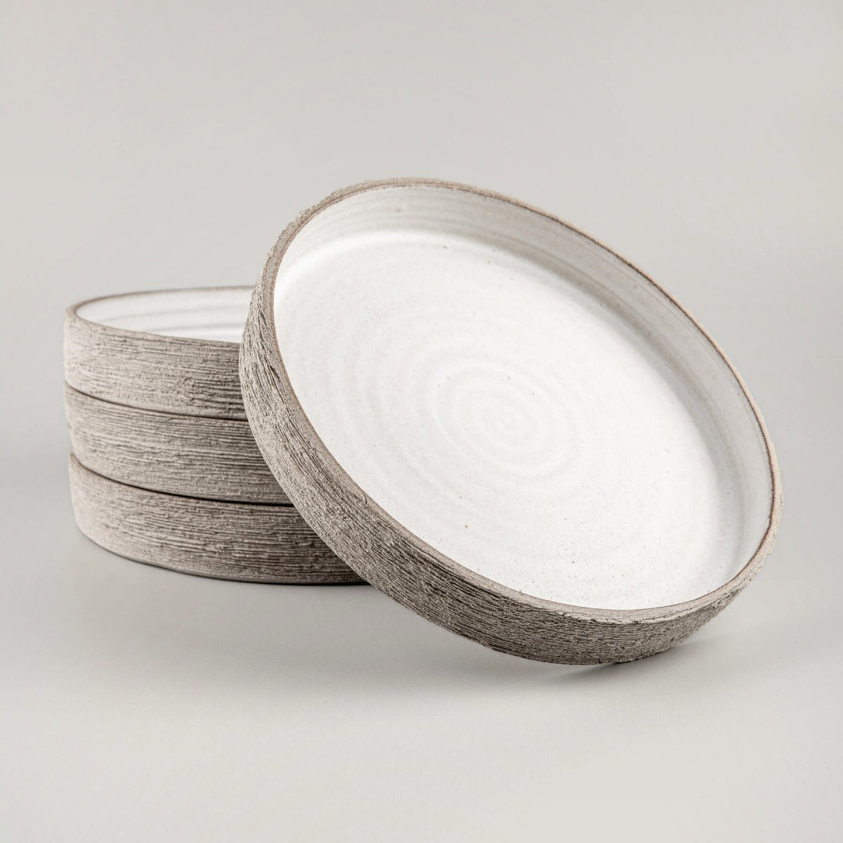 Handmade ceramic dinner plates with tall straight edges and matte white glaze interior.