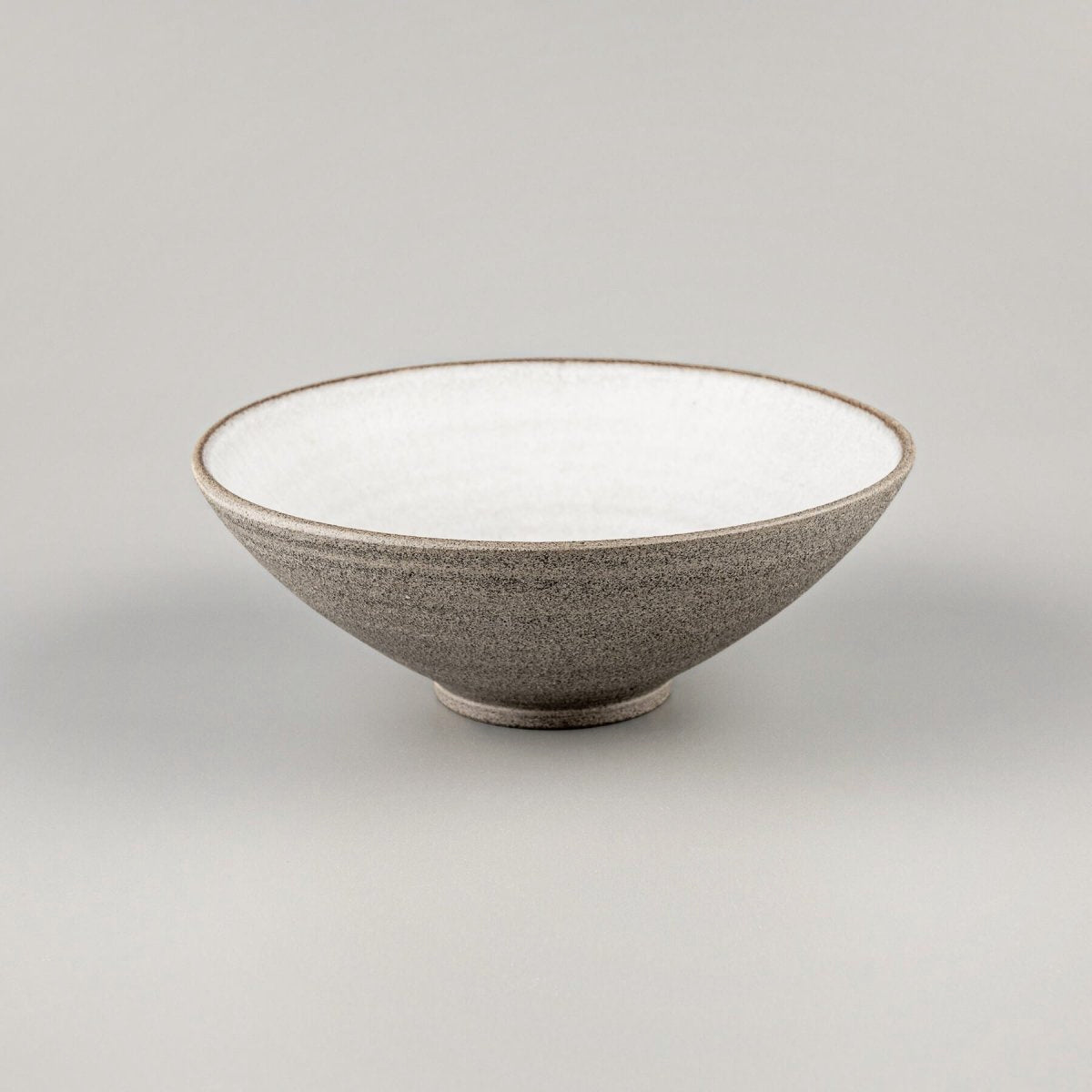 Side profile of artisan-crafted ceramic bowl with smooth lines and minimalist form.