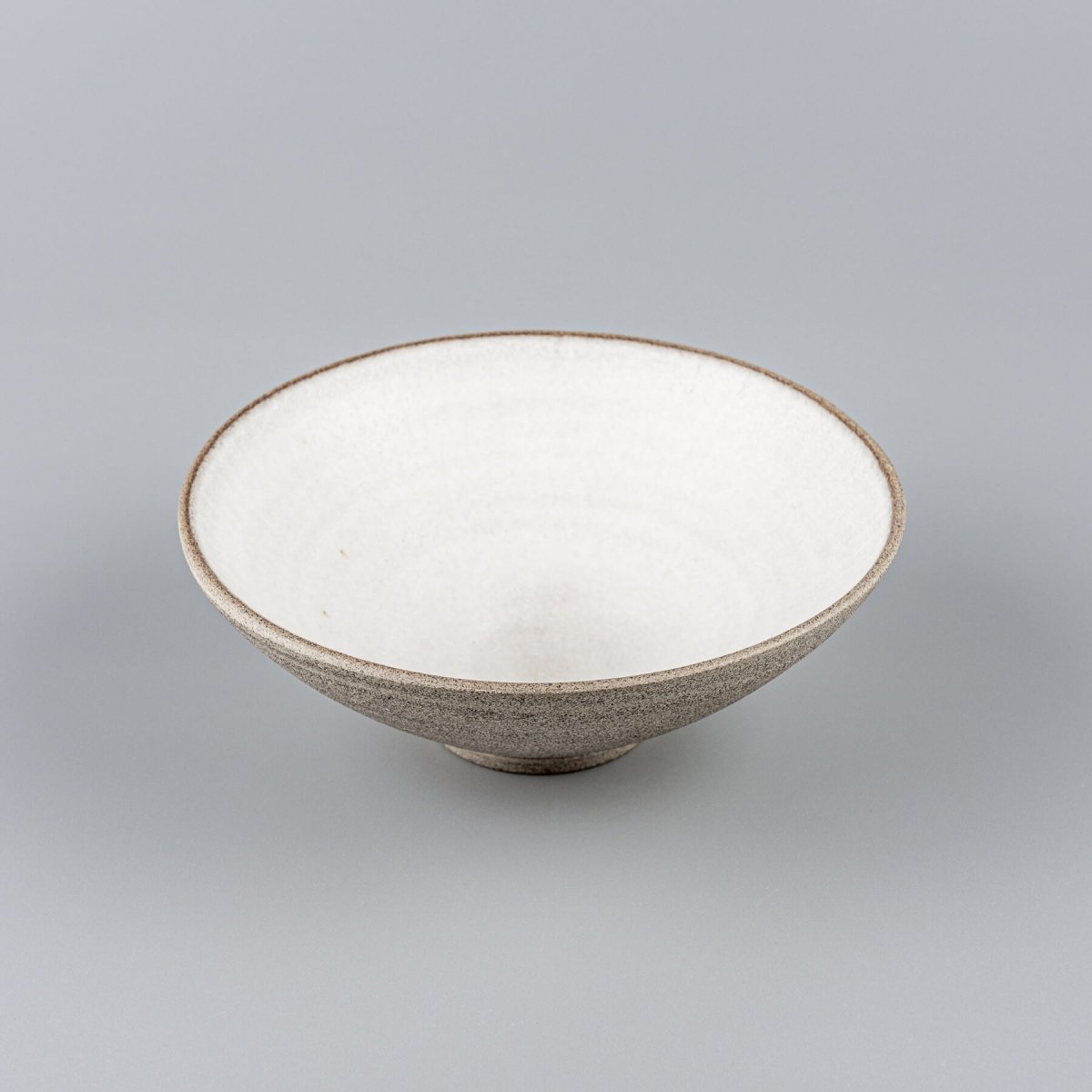 Angled view of ceramic bowl showing contrast between glazed interior and unglazed outer texture.