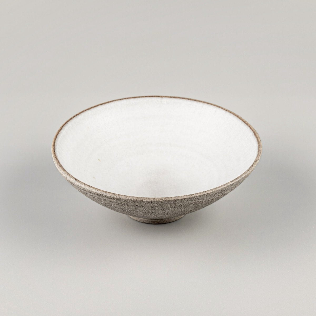 Angled view of ceramic bowl showing contrast between glazed interior and unglazed outer texture.
