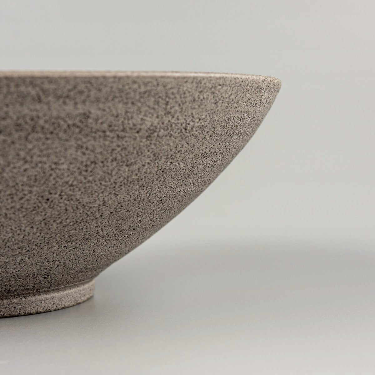Textured dark stoneware exterior of artisan ceramic bowl for high-end kitchenware.
