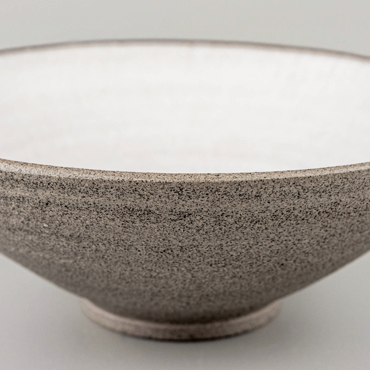 Base detail of handmade ceramic bowl with stable foot for elegant serving.