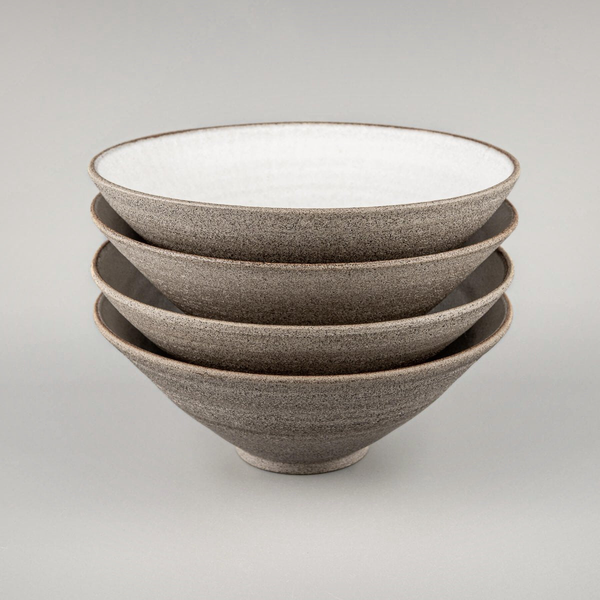 Stacked handmade ceramic bowls with matching design for restaurant use.