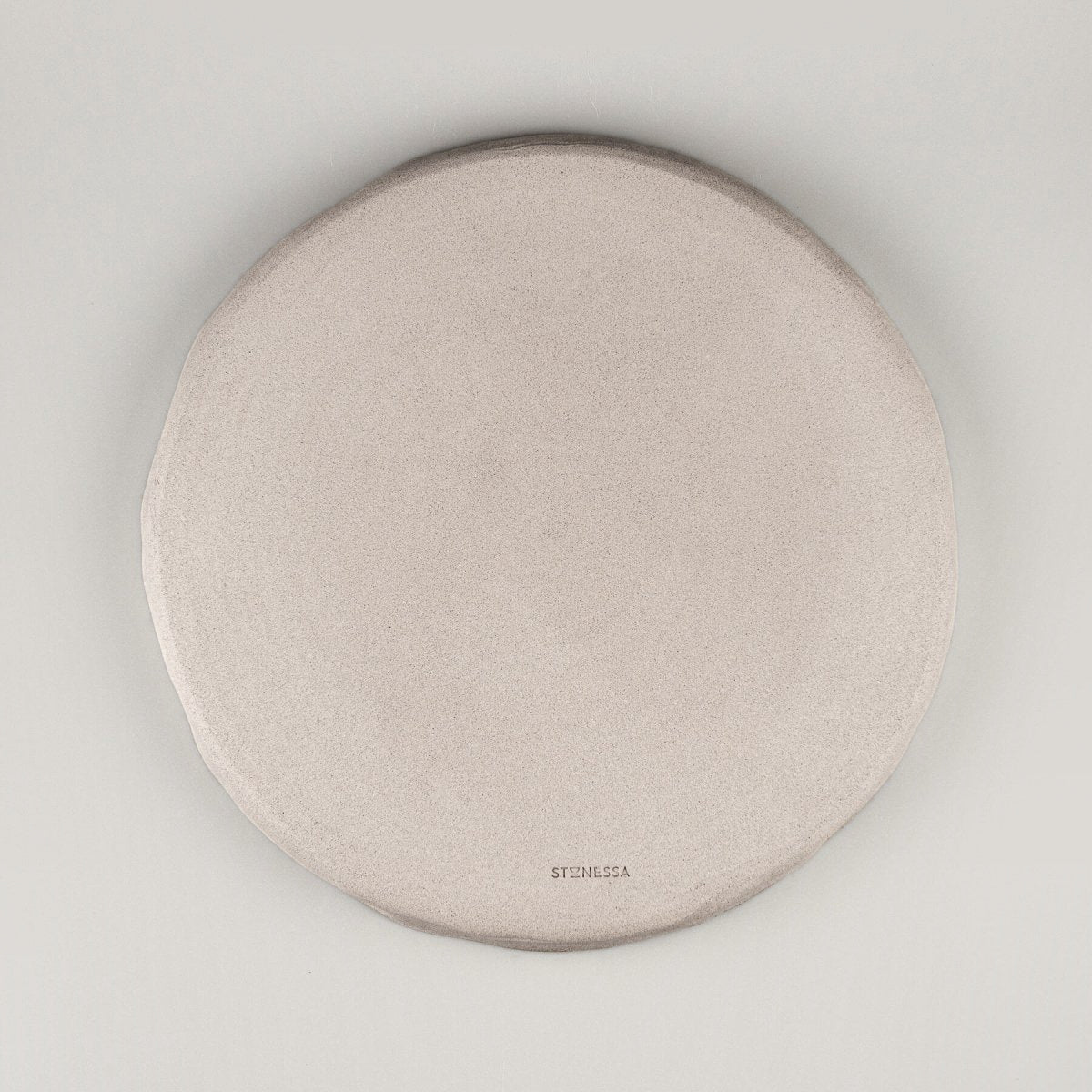 Bottom view of handmade dinner plate showing unglazed natural stoneware texture.