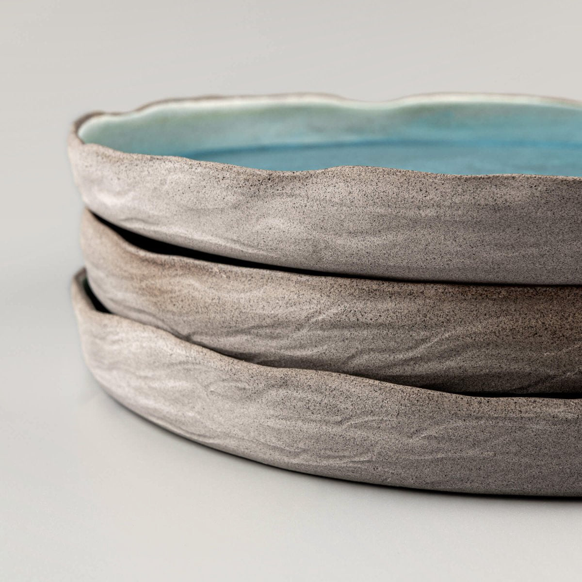 Set of handmade dinner plates in ocean-inspired turquoise for luxury tableware collections.