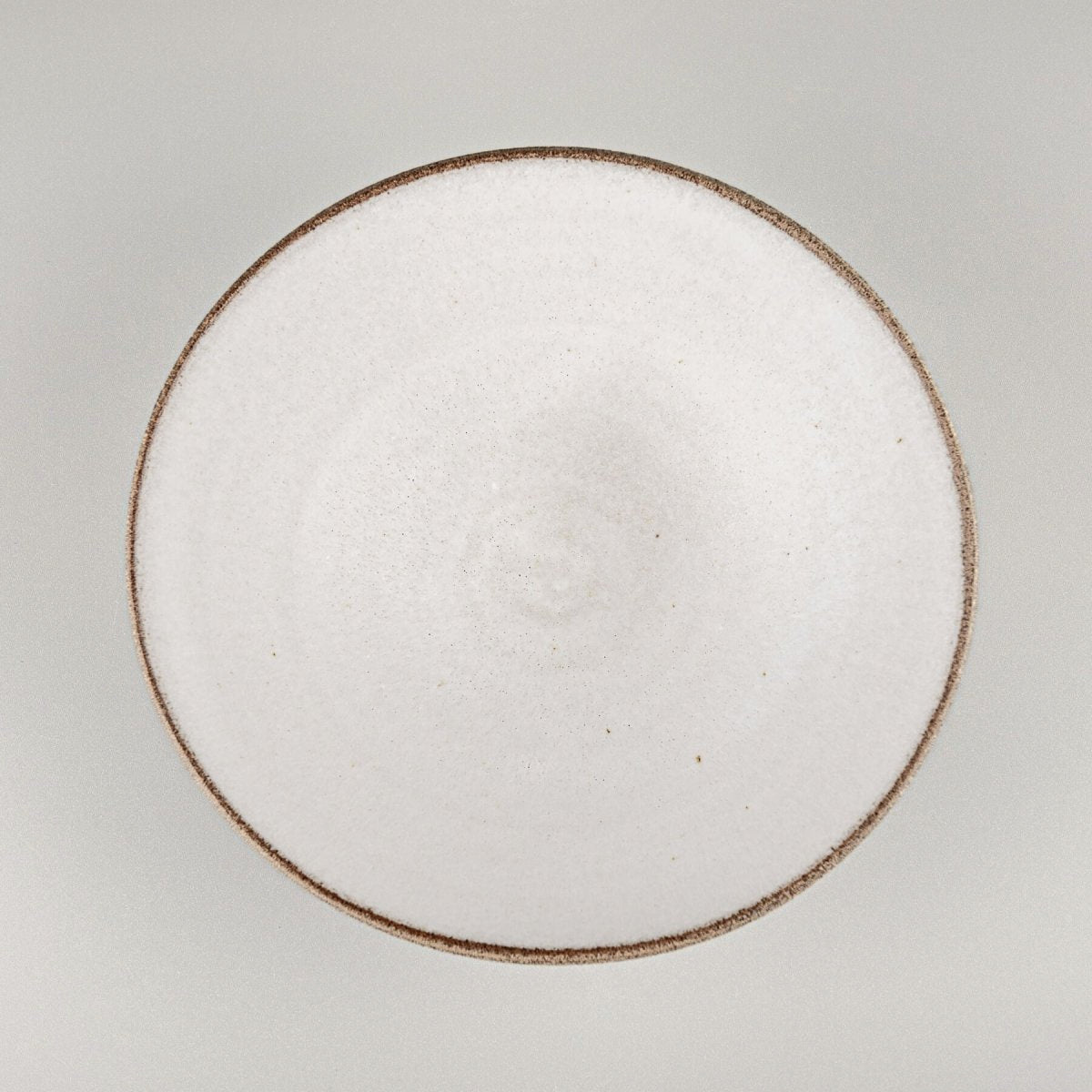 Minimalist white interior of handcrafted bowl perfect for culinary presentation.