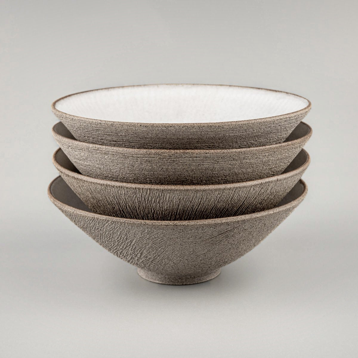 Stacked handmade bowls with refined texture and minimalist modern form.