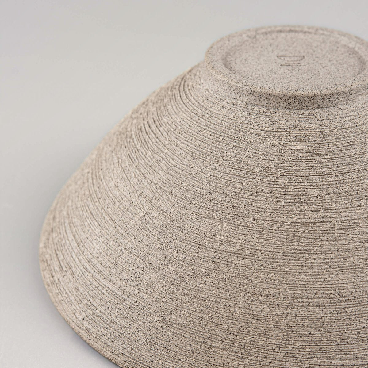 Texture focus on raw dark clay used for handmade serving bowls.