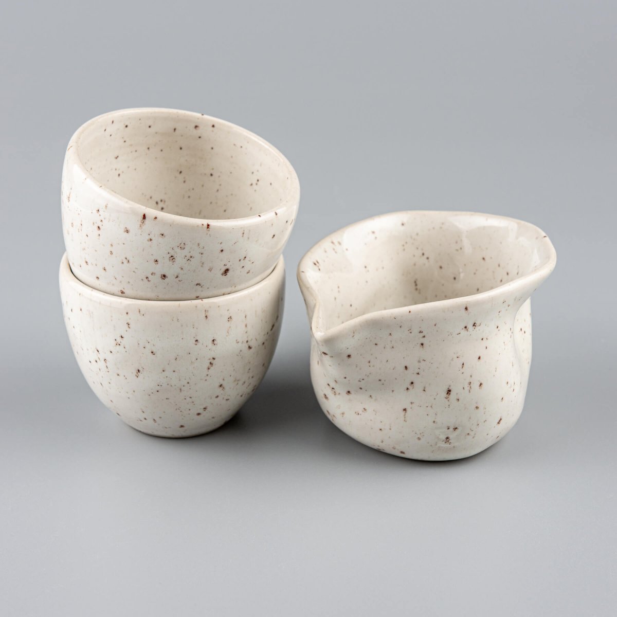 Handcrafted stoneware coffee cups and milk pitcher set with ivory glaze for fine dining and home kitchens.