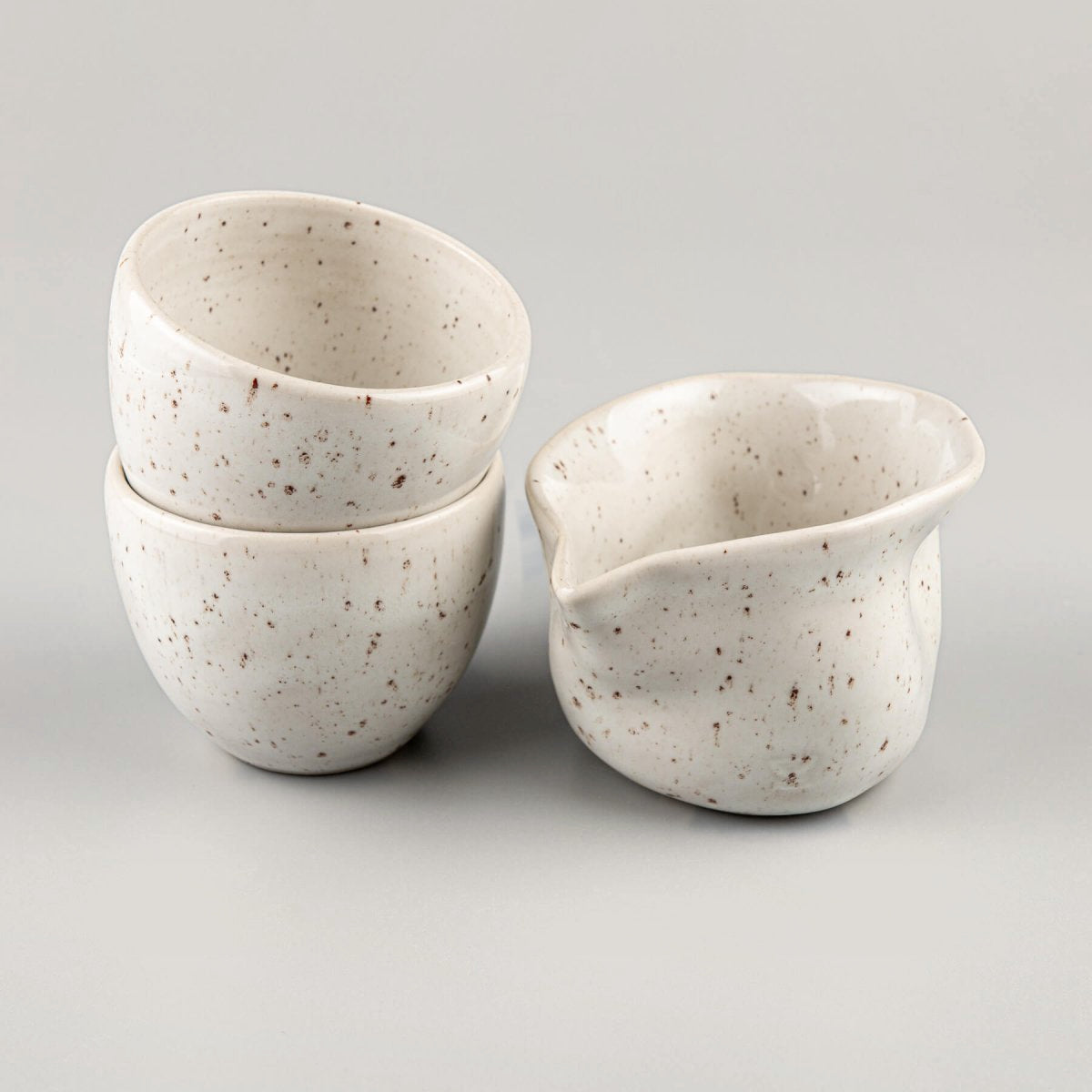 Handcrafted stoneware coffee cups and milk pitcher set with ivory glaze for fine dining and home kitchens.