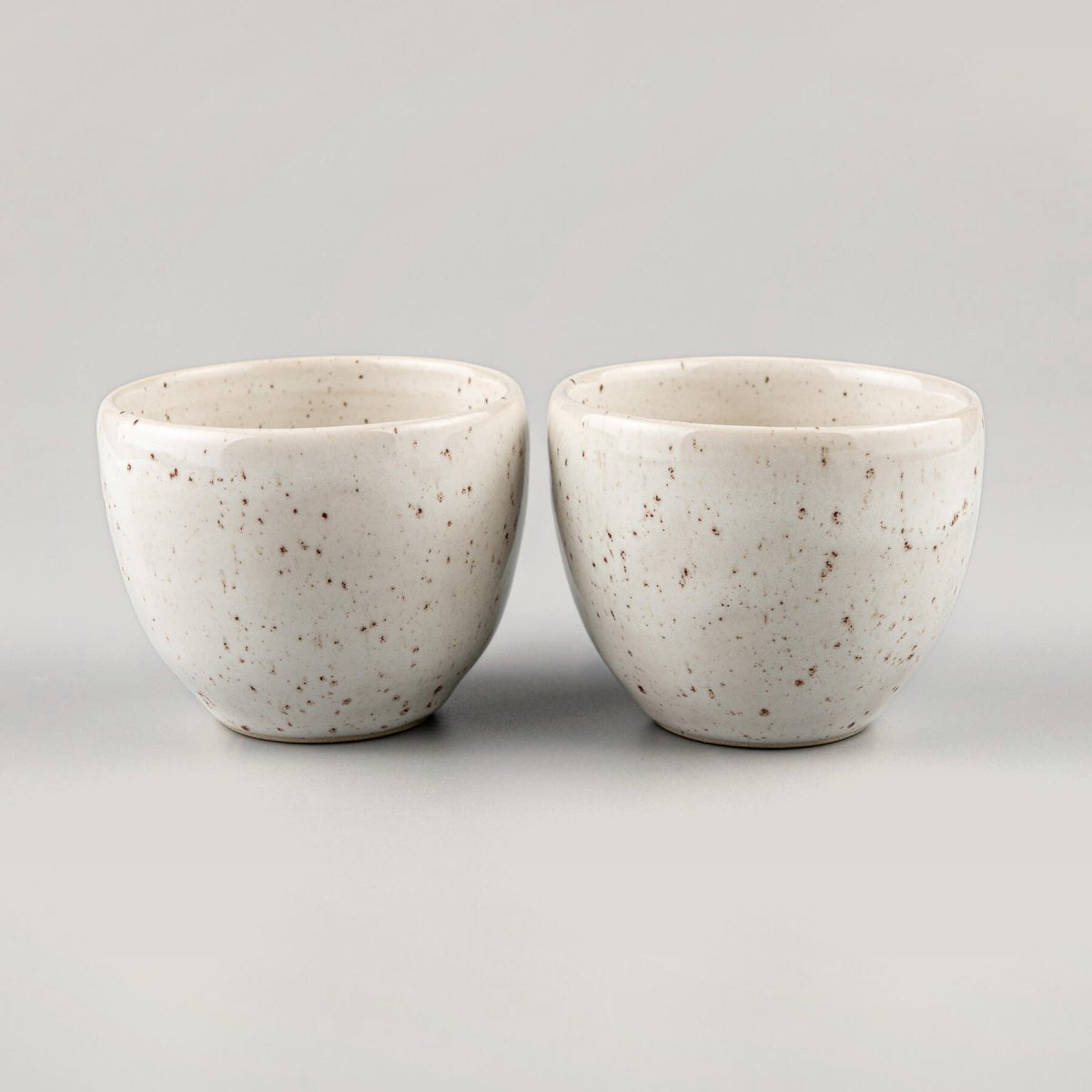 Rounded stoneware coffee cup with ivory glaze, ideal for espresso, tea, or artisanal kitchenware collections.