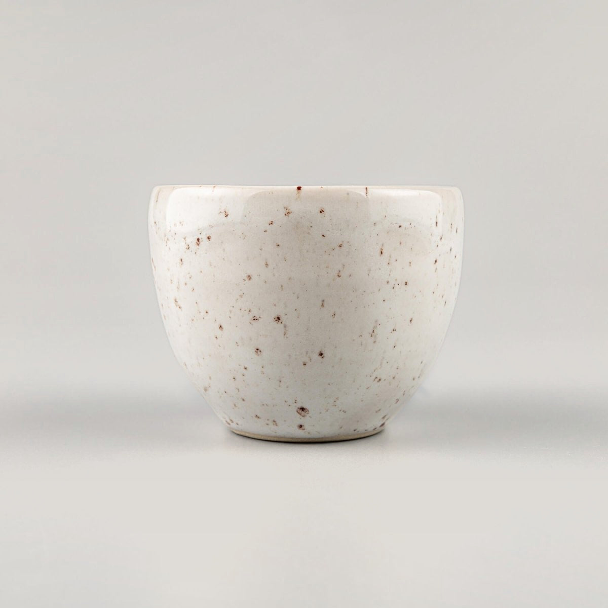 Elegant ivory-glazed stoneware coffee cup with natural speckle finish for boutique hotel tableware.