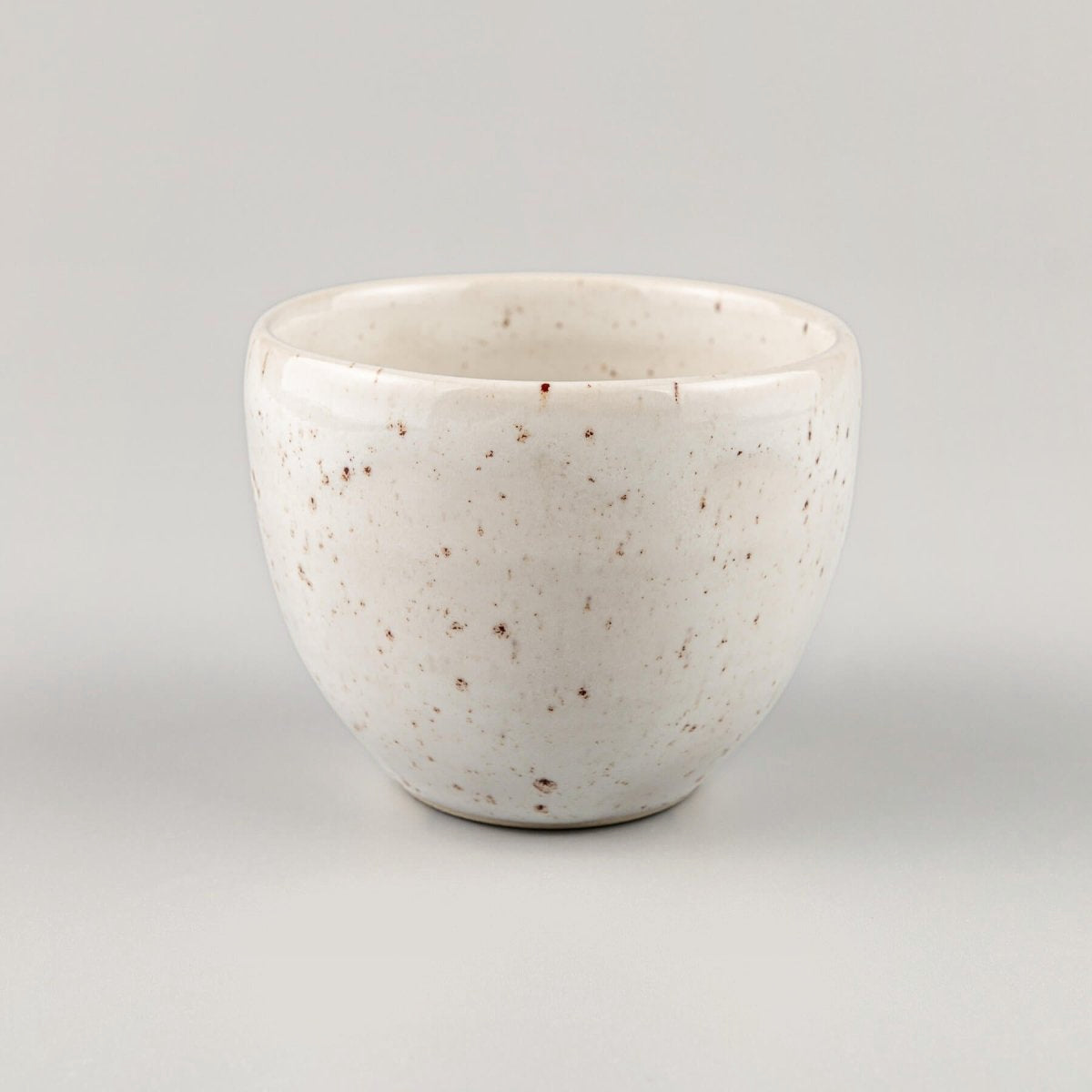 Handcrafted ivory-glazed stoneware coffee cup with speckled finish, perfect for fine dining restaurants and boutique hotels.