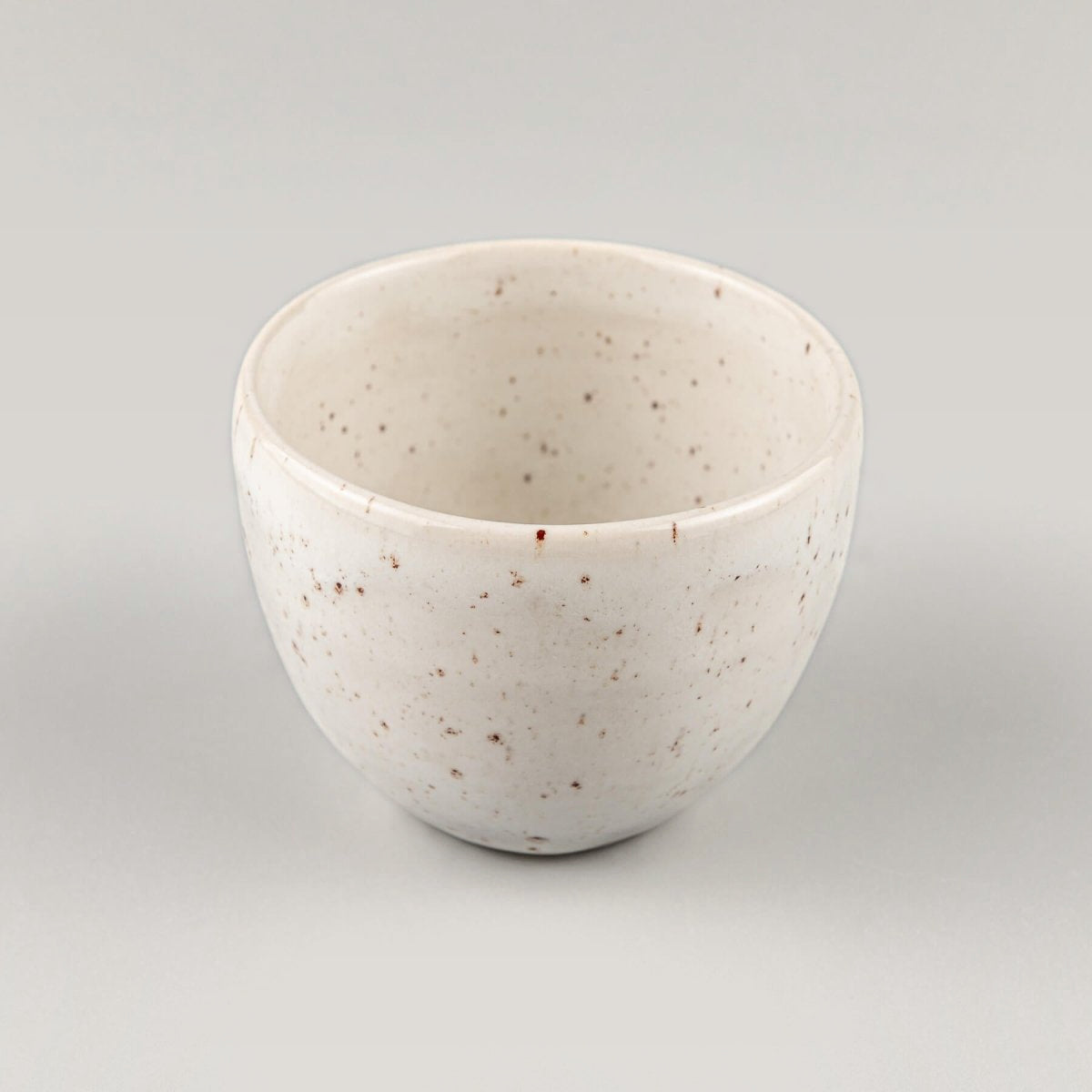 Minimalist stoneware coffee cup in ivory glaze with rounded shape, ideal for home kitchens, restaurants, and interior design.