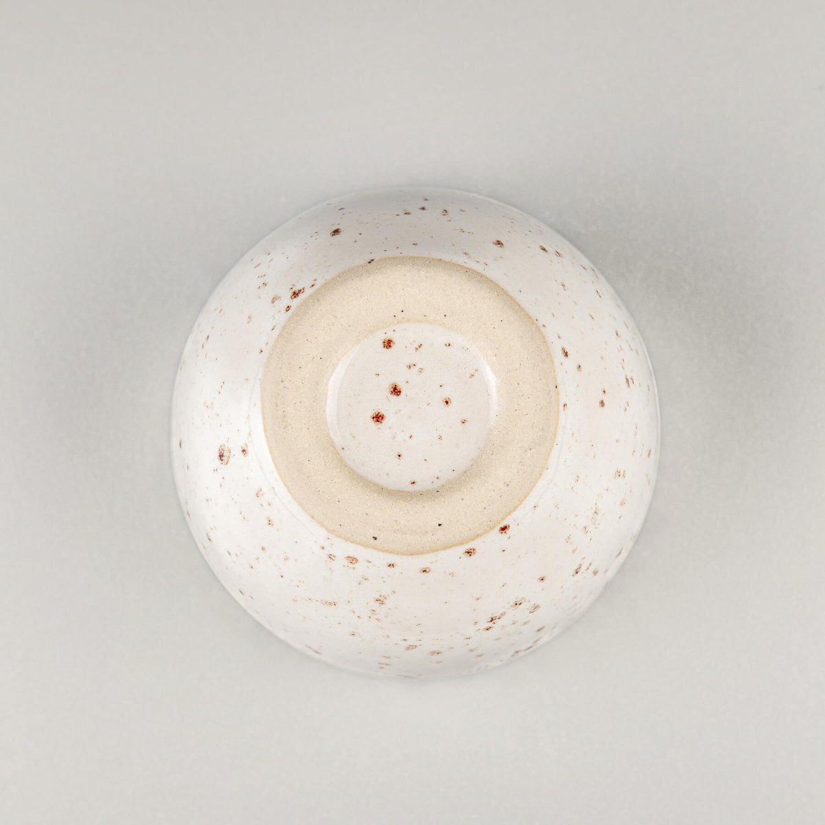 Bottom detail of artisanal stoneware coffee cup, collectible pottery for fine dining and interior design.