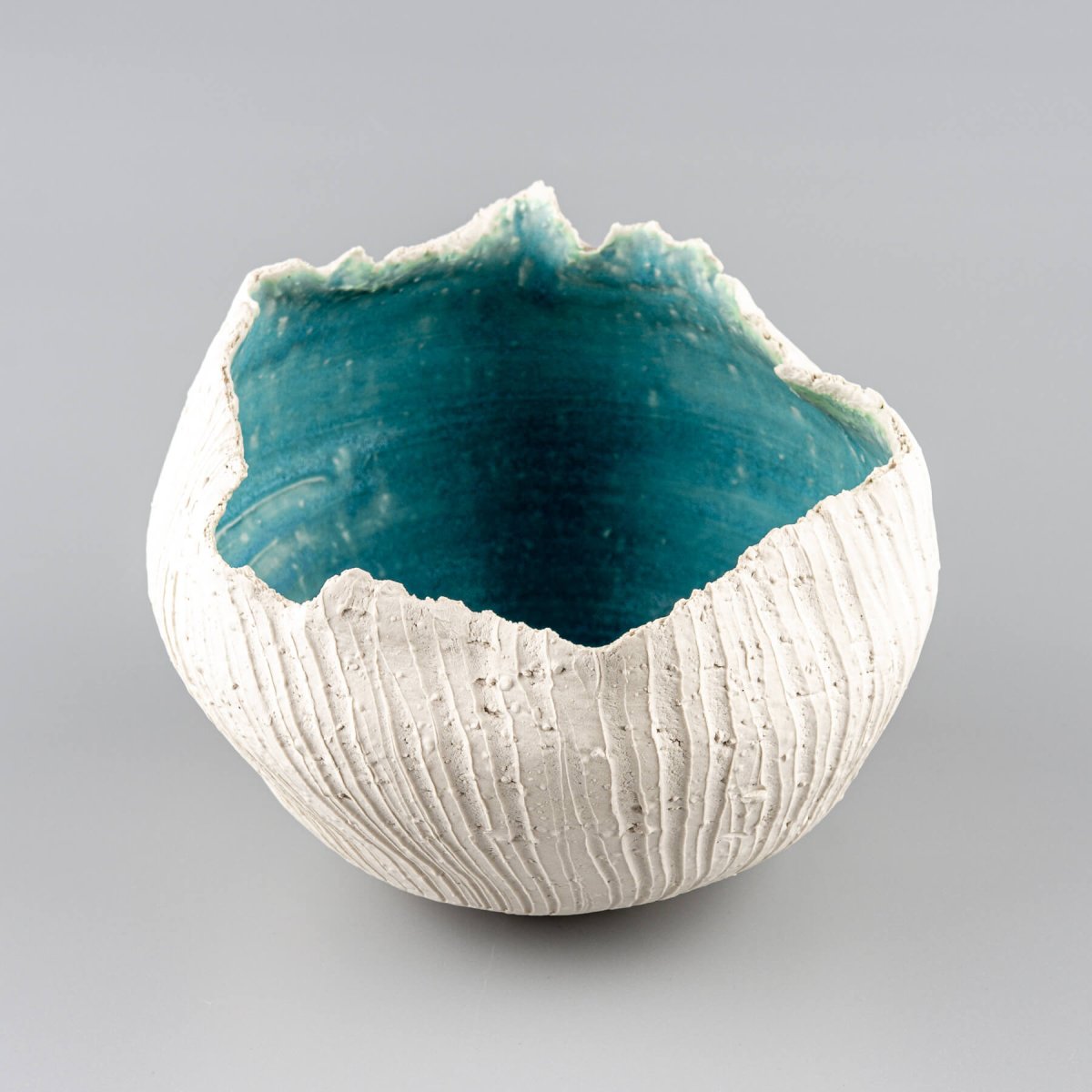 Artisan-crafted pottery vase with textured shell-like surface and deep turquoise finish for collectible pottery.
